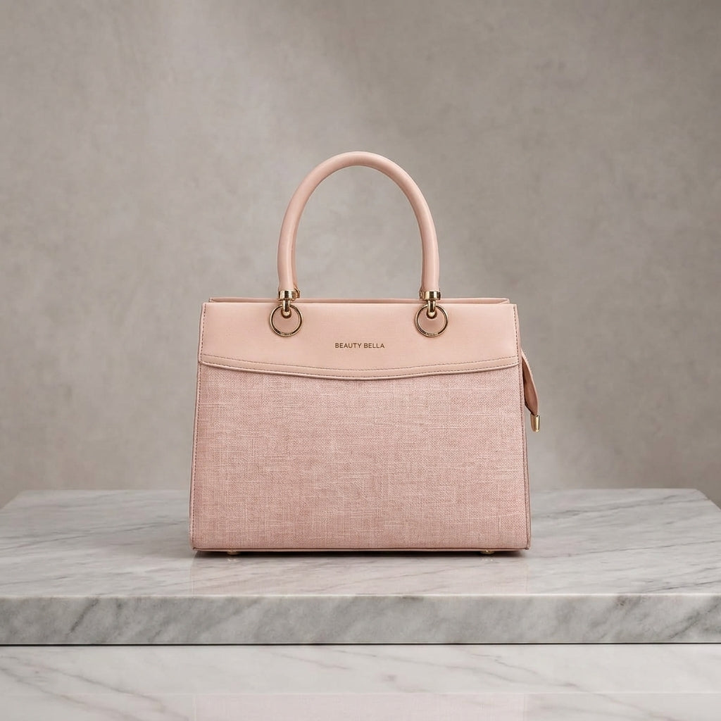A structured light pink handbag with a textured front panel, smooth top handle, and gold-tone hardware, displayed on a white marble surface against a neutral gray background.